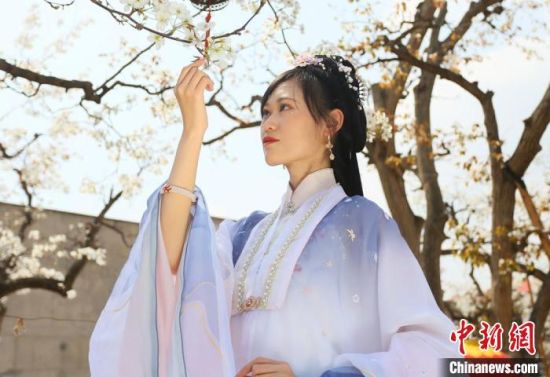 圖為蘭州青年身穿漢服在百年梨園賞景?！「哒?攝