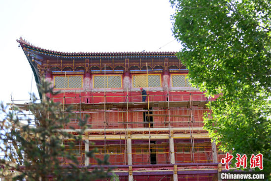 圖為5月上旬，甘肅山丹縣大佛寺內(nèi)，工作人員對(duì)古建筑大雄寶殿進(jìn)行修繕。 中新社記者 高展 攝