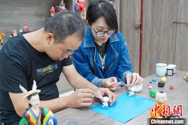 <a target='_blank'  data-cke-saved- >中新社</a>記者(右)現(xiàn)場體驗(yàn)面塑制作過程?！￡悹帍?qiáng) 攝