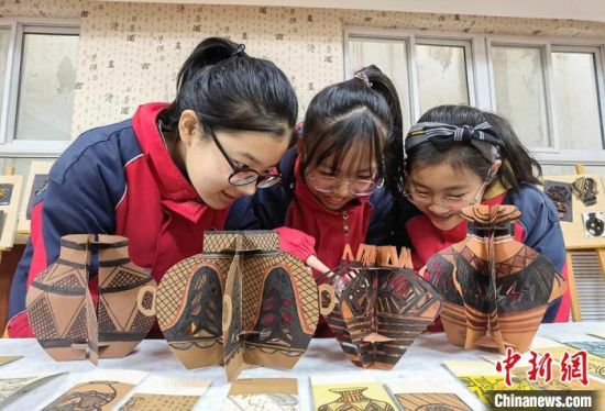 圖為學(xué)生用紙創(chuàng)作的立體彩陶?！⒂裉?攝