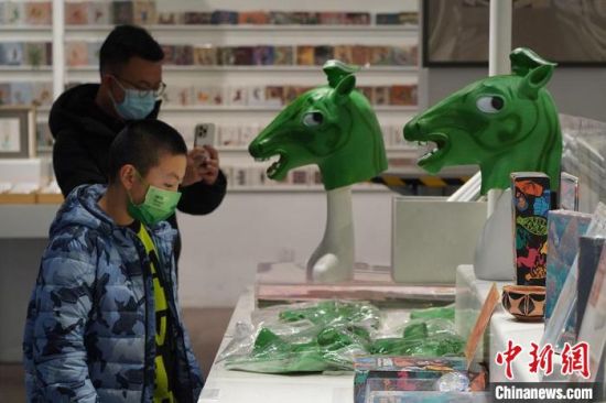 圖為“神馬來了”銅奔馬頭套吸引參觀者駐足?！【琶赖┰?攝