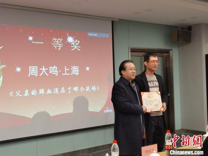 圖為作家、西北師范大學(xué)新聞與傳媒學(xué)院院長徐兆壽頒發(fā)一等獎(jiǎng)證書，代領(lǐng)獎(jiǎng)?wù)呱吓_(tái)領(lǐng)獎(jiǎng)?！钅?攝