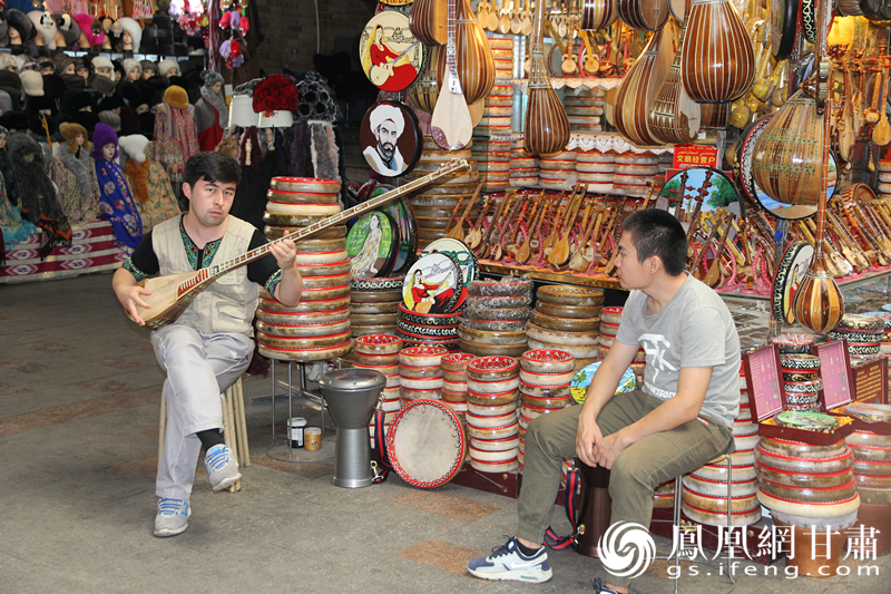 烏魯木齊二道橋巴扎內(nèi)，店主正在向客人展示樂器。楊文遠 攝