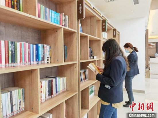 圖為在甘肅公航旅建設(shè)集團(tuán)有限公司的職工書屋，職工挑選書籍。　徐雪 攝