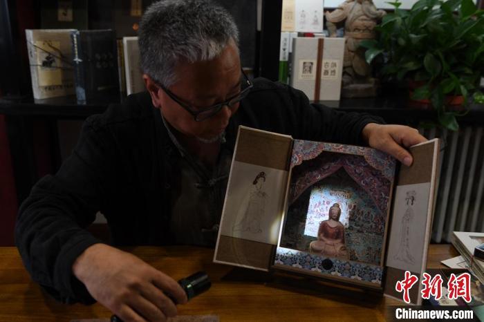 圖為讀者出版集團讀者晉林工作室獨立出品人徐晉林，展示互動性強的敦煌題材手工書。(資料圖) 楊艷敏 攝