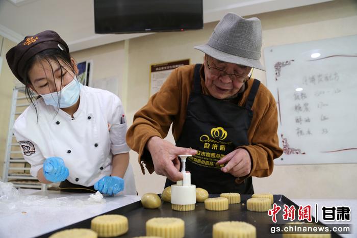 當(dāng)日，受邀參加活動的臺胞臺屬代表、兩岸婚姻及子女、在甘臺商代表等歡聚一堂。圖為77歲的在甘臺胞潘天鑒制作月餅。九美旦增 攝