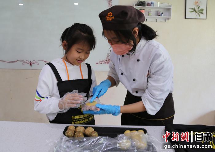 圖為在甘臺胞小朋友在工作人員指導(dǎo)下制作月餅。九美旦增 攝