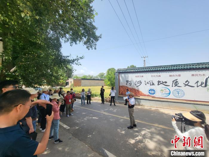圖為中國地質(zhì)大學(xué)(北京)教授張緒教介紹村落情況?！『衍?攝