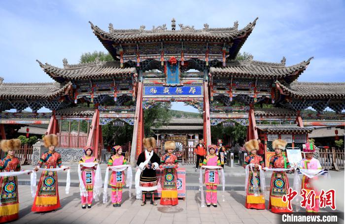 圖為身穿土族服飾的工作人員迎接訪客?！⊙Φ?攝