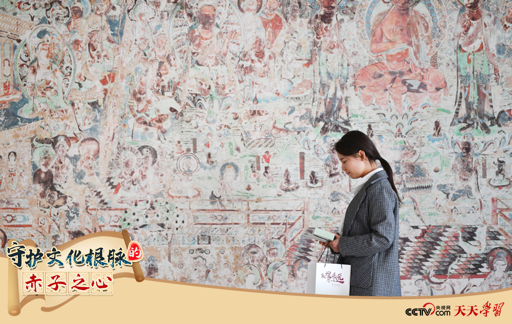 2023年4月25日，敦煌研究院文物數(shù)字化保護團隊創(chuàng)意營銷人員廖雪婷從一幅高保真復制壁畫前走過。