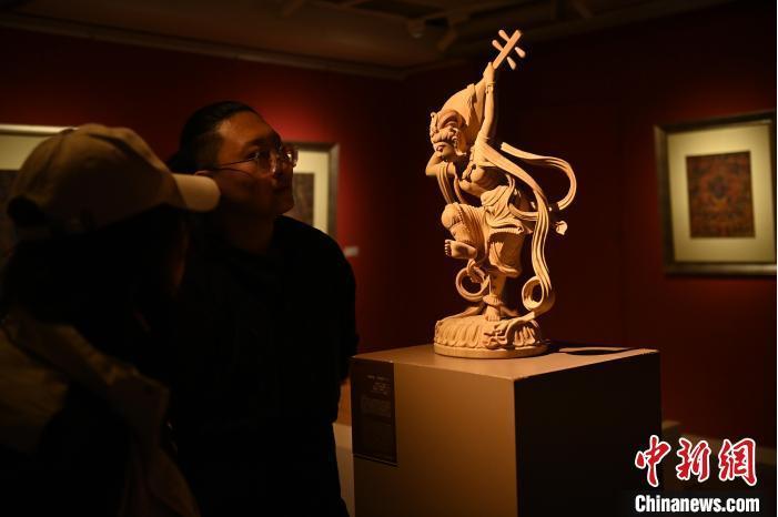 圖為季茂杰向參觀者介紹自己創(chuàng)作敦煌木雕的過(guò)程。李亞龍 攝</p>
<p>