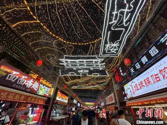 圖為明清街夜市燈光點(diǎn)亮具有武威文化元素的“涼州古城門”彩燈?！〈魑牟?攝</p><p>