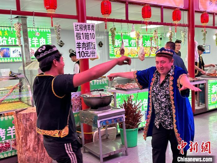 圖為餐飲經(jīng)營者在“西涼不夜城”跳起舞蹈引客?！〈魑牟?攝</p><p>